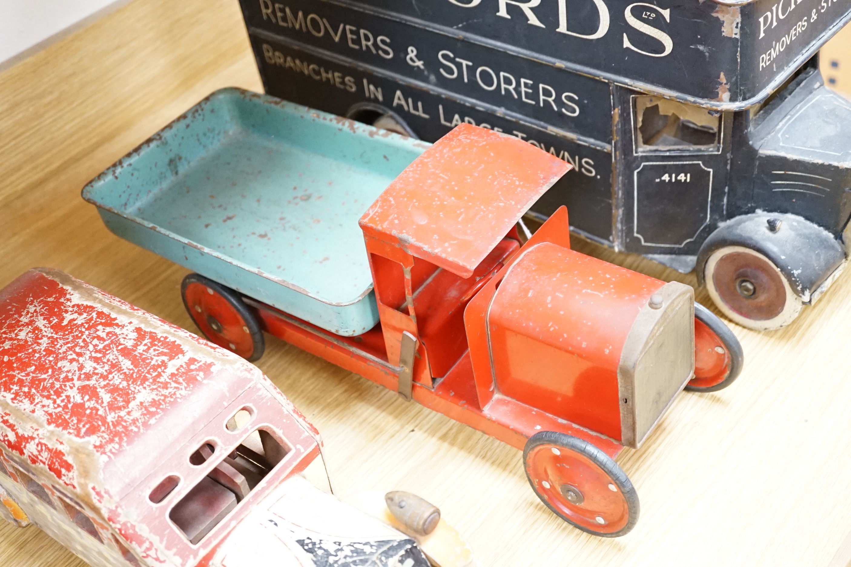 Three model vehicles including; a tinplate Tri-ang tipper lorry, a Pickfords removal van (believed to have been used as a shop window display) and a wooden bus, length of Pickfords van 54cm